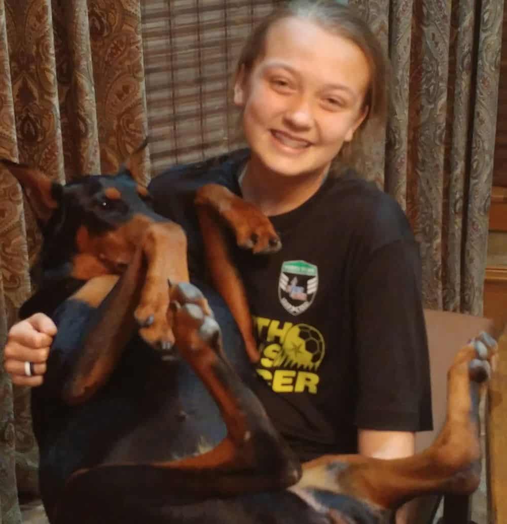 black and rust male doberman with child holding